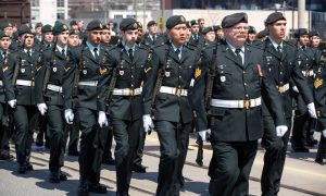 Group of men walking the city streets, wearing a black military uniform